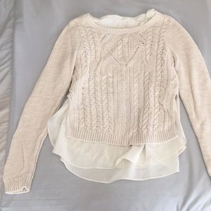 Layered cable knit sweater.